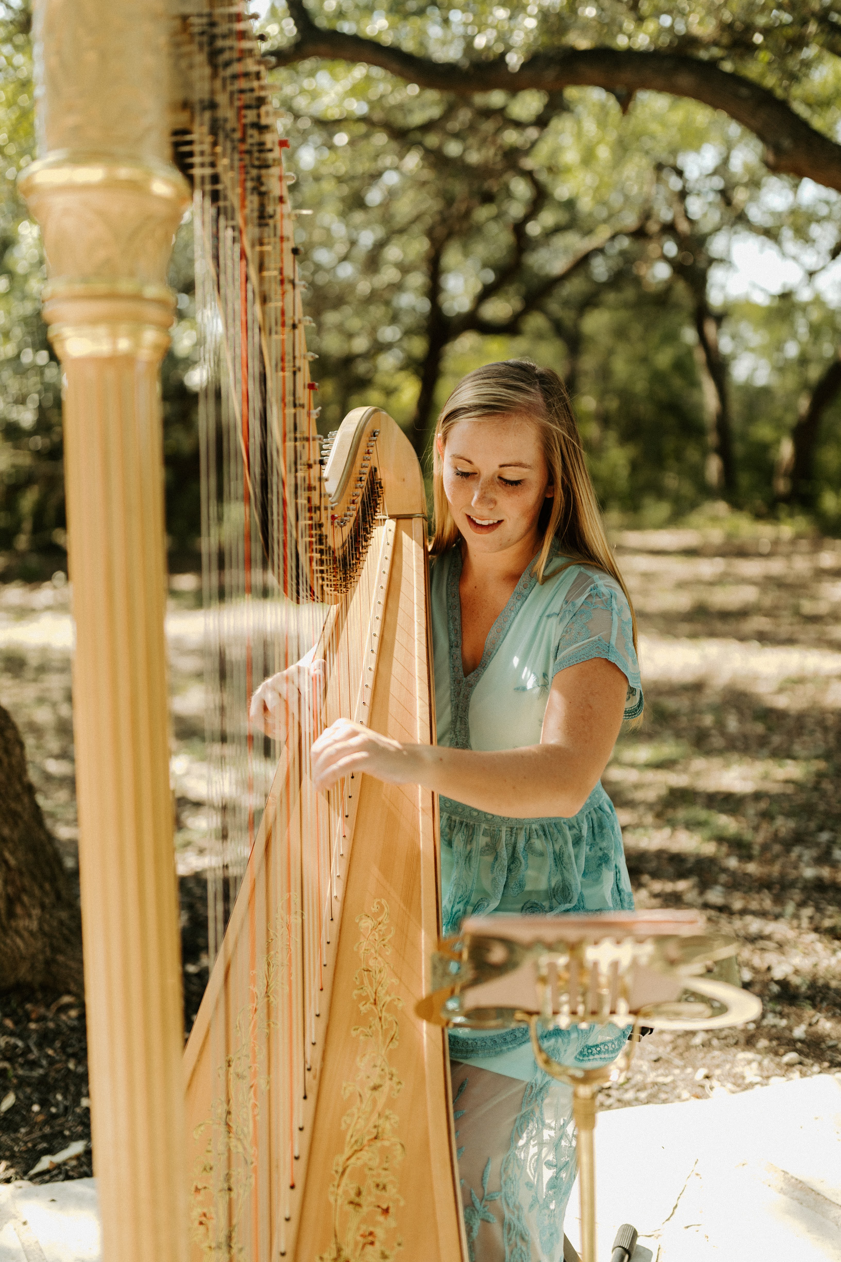 Grace performing harp at an outdoor wedding